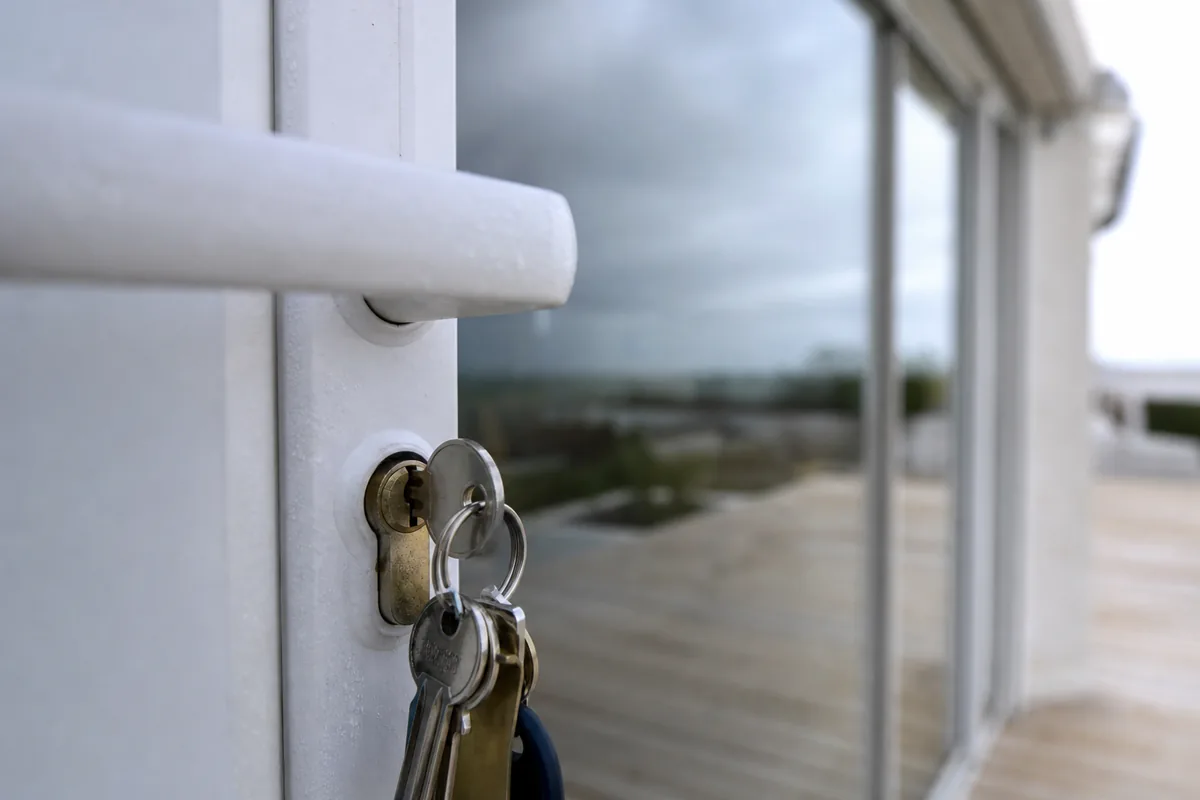 Porte d&rsquo;entrée en aluminium d&rsquo;une résidence de bord de mer, cylindre marqué par l&rsquo;air salin