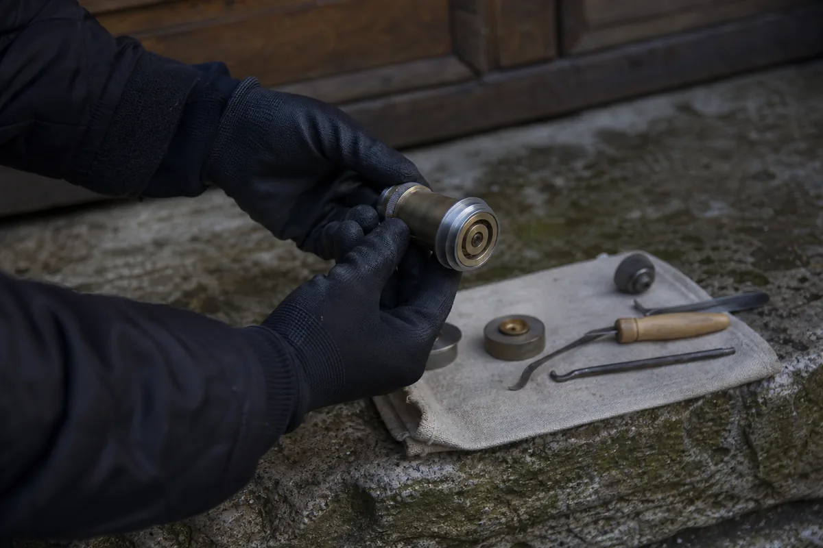 Mains gantées manipulant un cylindre européen et un trousseau de clés sur un seuil