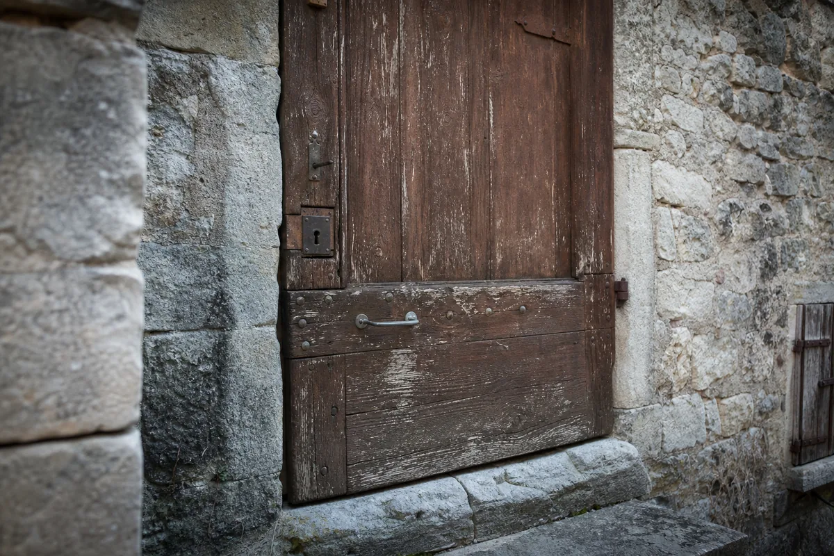 Porte en bois plein d’une maison de village gardoise avec sa serrure à gorges d’origine